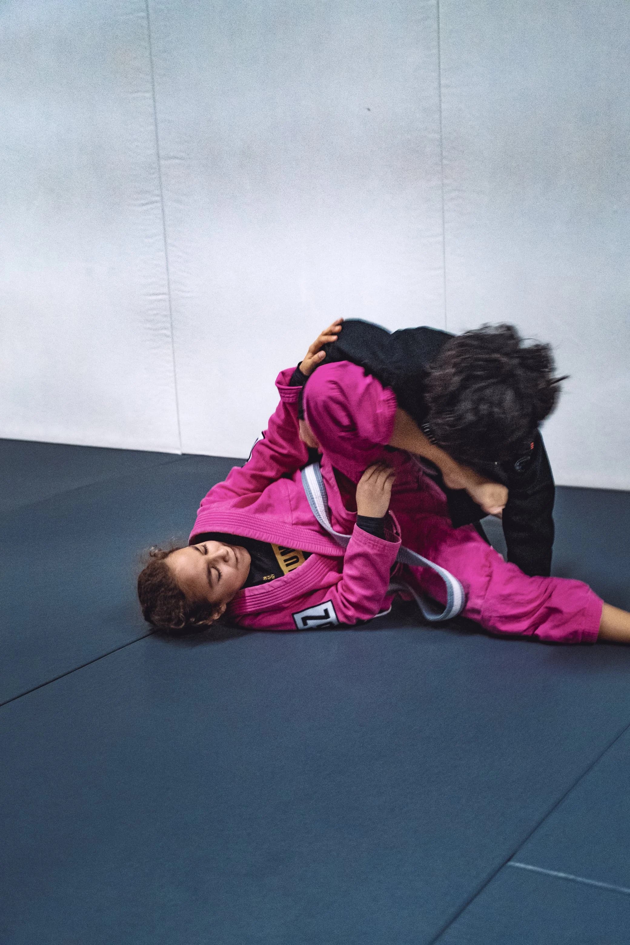 Two women rolling in Gi at GrappleZone